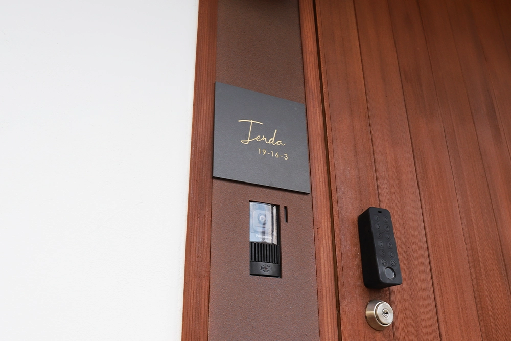 茶色の壁に黒いタイル表札の画像