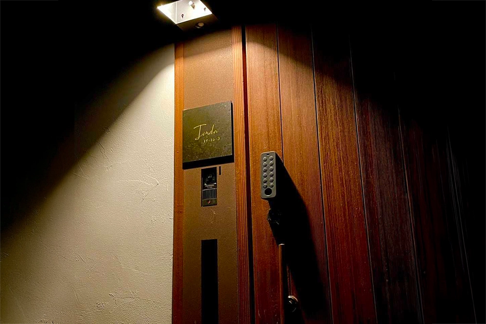 夜照明に照らされた表札の画像